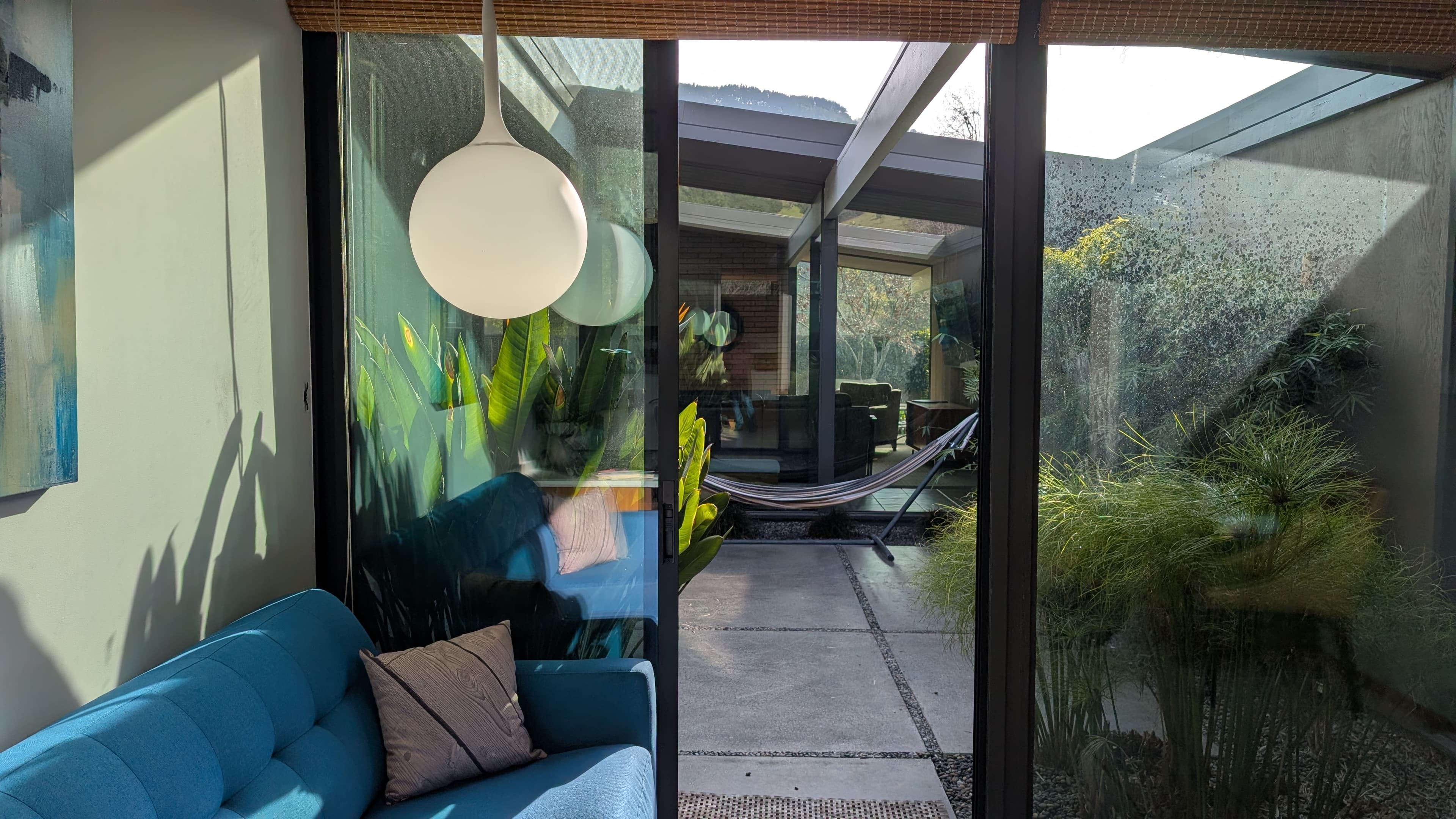 View from Elizabeth's home office into a lush courtyard with plants and a hammock